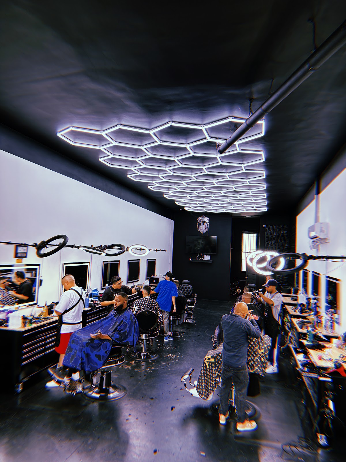 The shop floor busy, every chair taken under the hexagon LED ceiling
