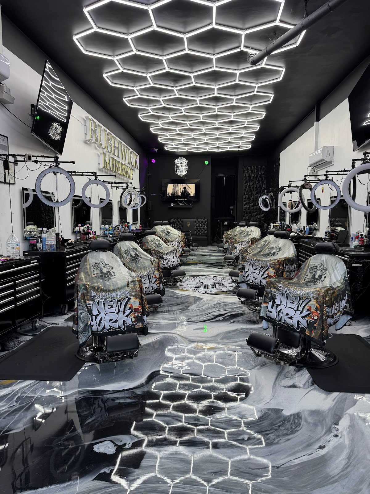 The Bushwick Barbershop floor, hexagon LED ceiling above a black and white marble epoxy floor